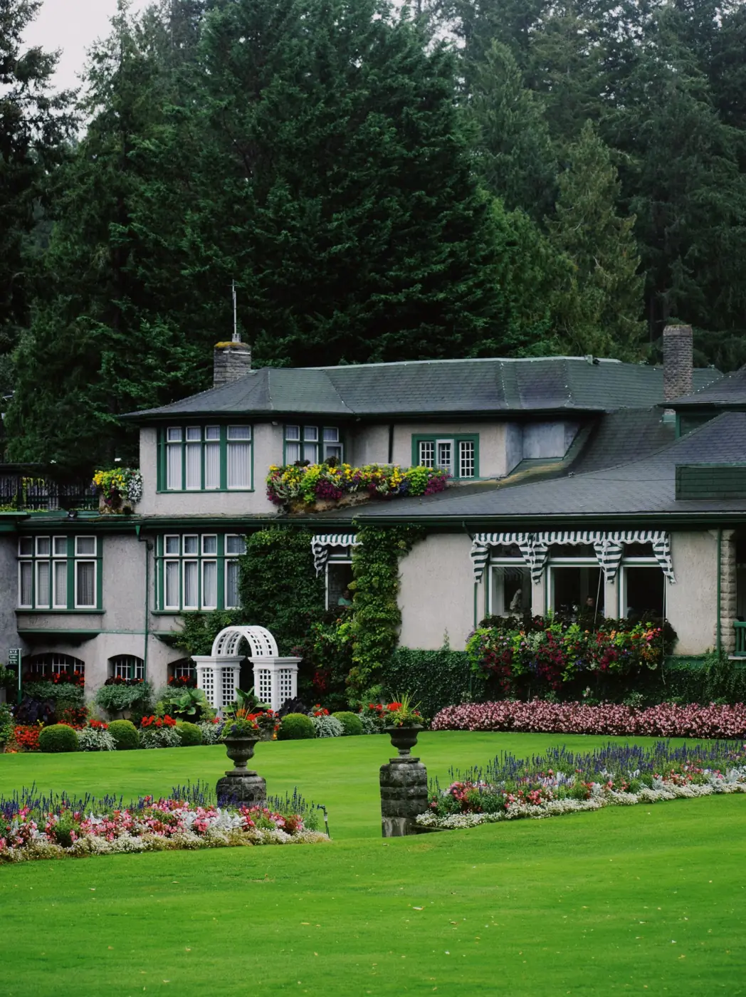 Country house with a manicured lawn and colourful flower beds