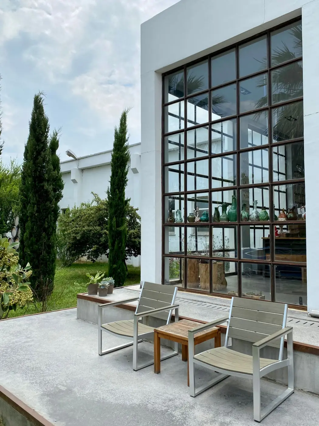 Modern garden room with large windows, chairs and planting outside